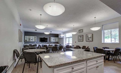 A kitchen with a large island and chairs around it.