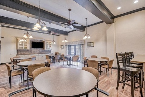 A spacious dining area with a large table surrounded by chairs.