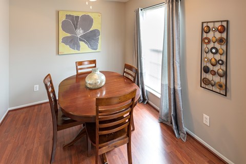 A dining room with a wooden table and chairs.