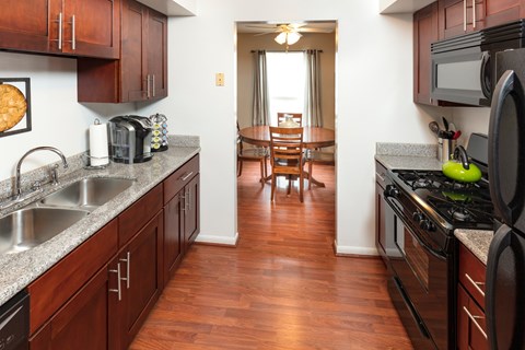A kitchen with wooden cabinets and a stove top oven.