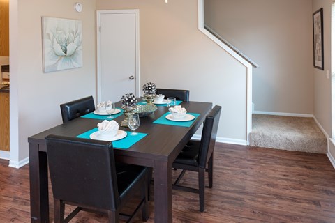 A dining table with four chairs and a blue placemat.