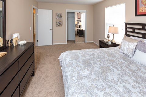 A bedroom with a large bed and a dresser.