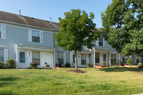 A row of houses with green lawns in front.