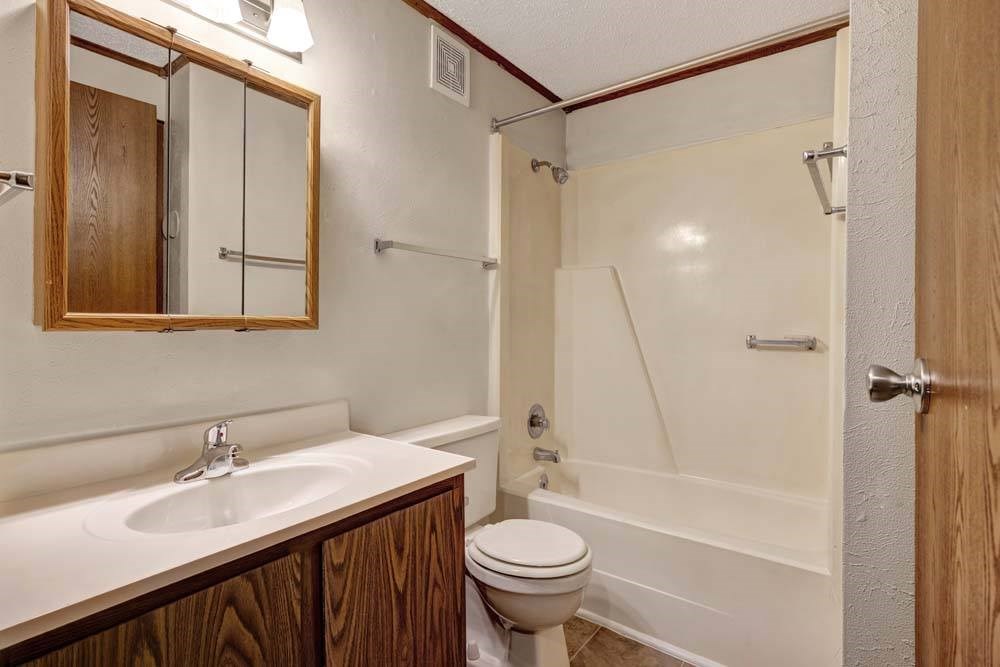A bathroom with a toilet, sink, and shower.
