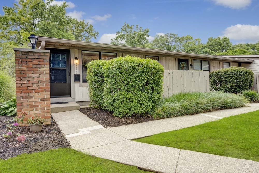 A house with a brick pillar and a white door.