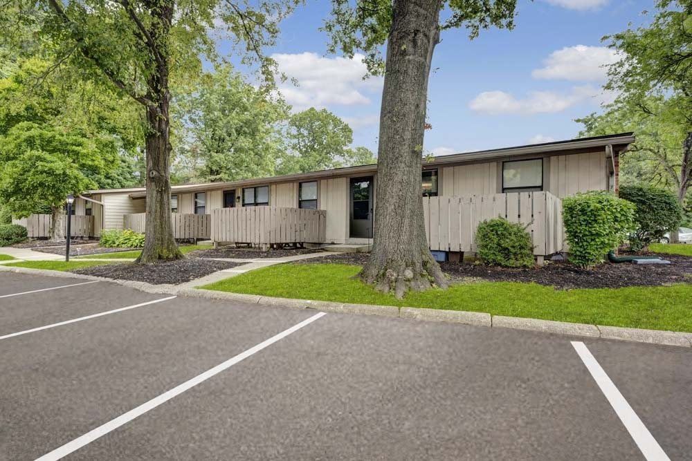 A parking lot in front of a building with trees.