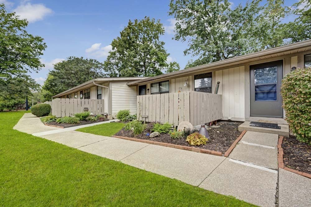 A row of houses with a green lawn in front.