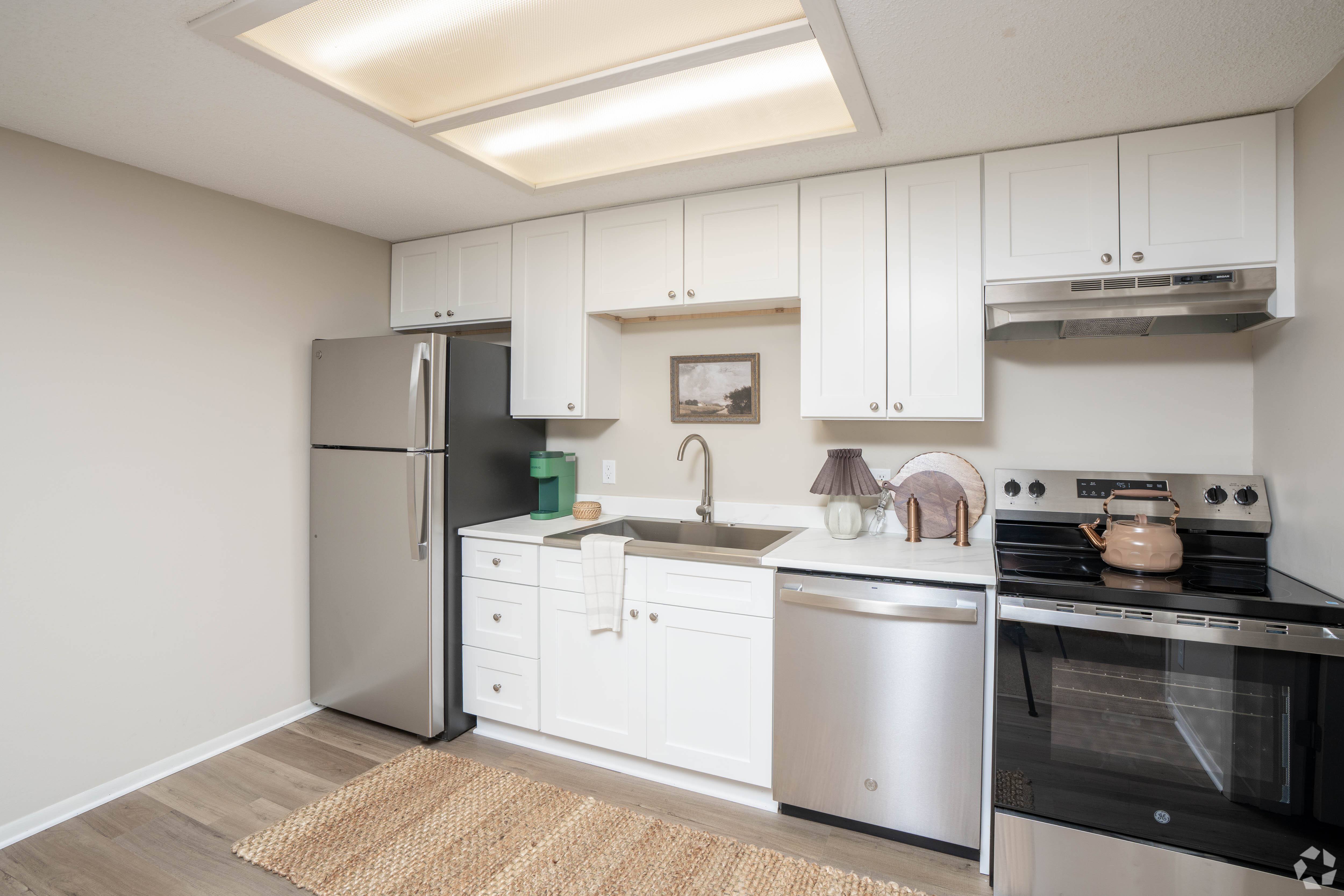A kitchen with white cabinets and stainless steel appliances.