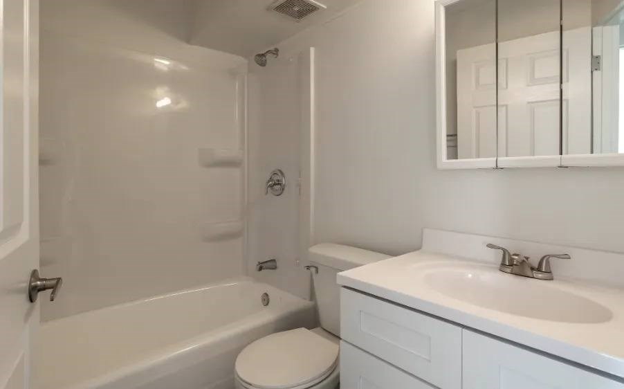 A white bathroom with a toilet, sink, and bathtub.