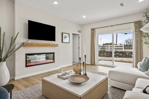 A modern living room with a fireplace and a flat screen TV mounted above it.