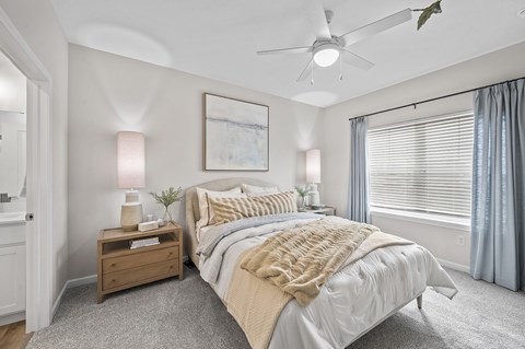 A bedroom with a large bed and a ceiling fan.