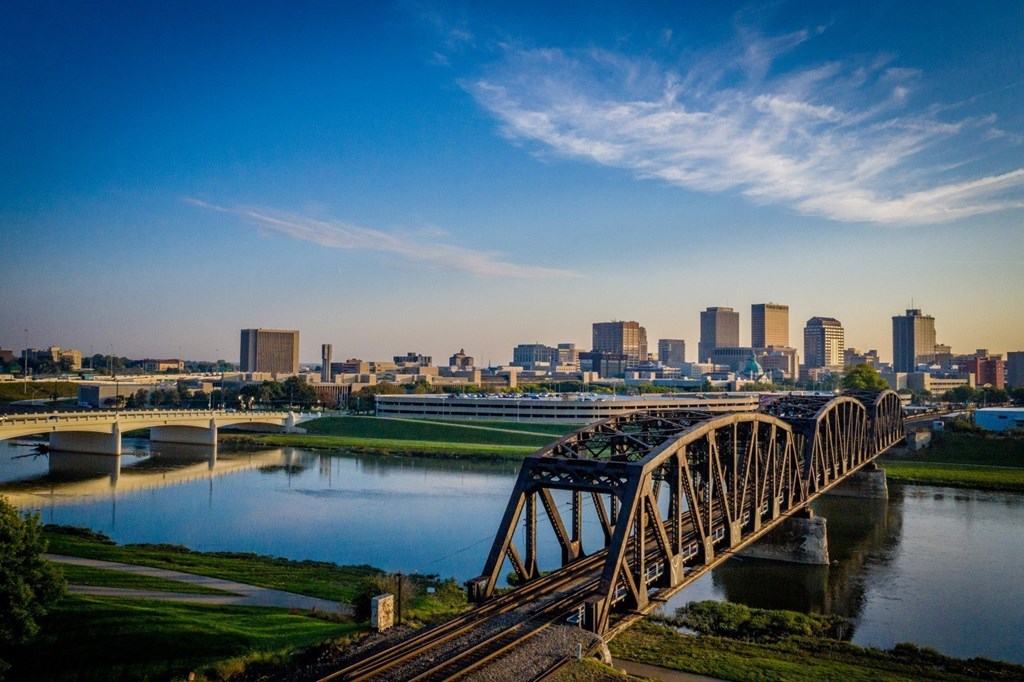 A bridge spans a river with a city skyline in the background.