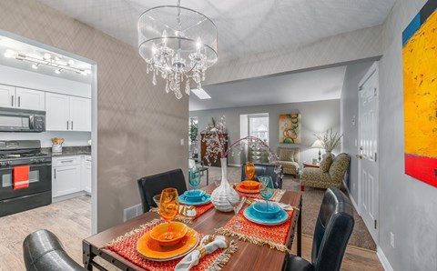 A dining room with a table set for a meal.