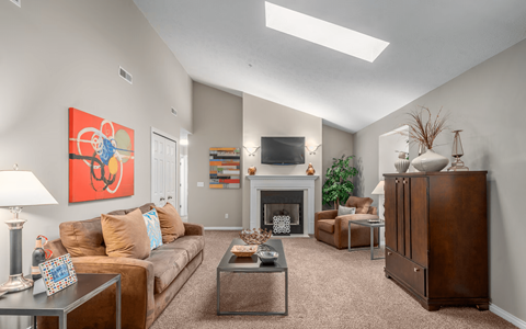 A living room with a fireplace and a painting on the wall.