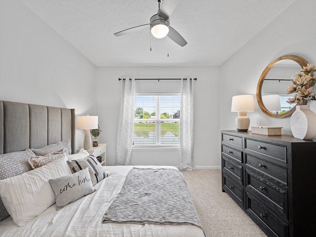 a bedroom with a large bed and a ceiling fan