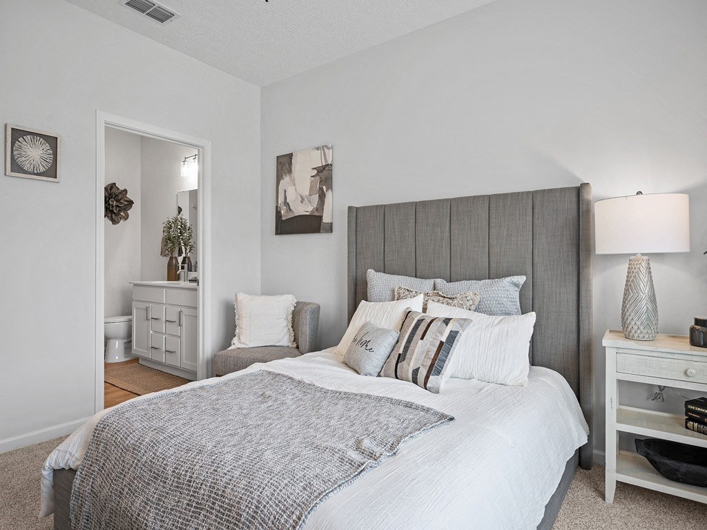 a bedroom with a large bed and a bathroom with a sink