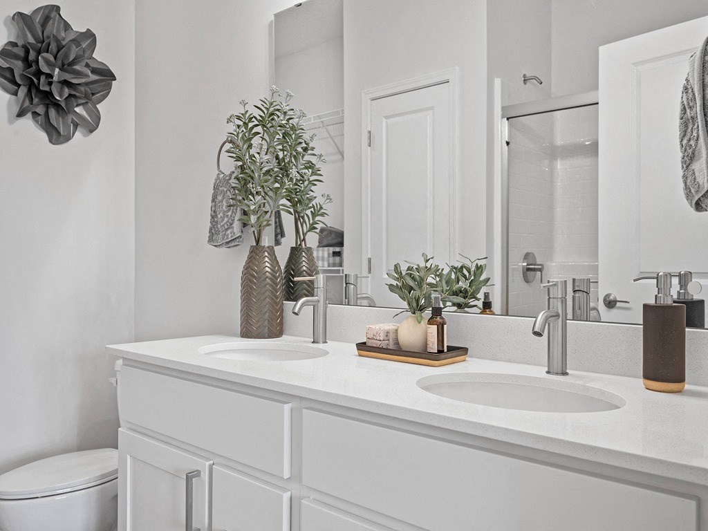 a white bathroom with two sinks and a mirror