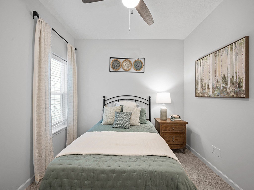 a bedroom with a bed and a ceiling fan