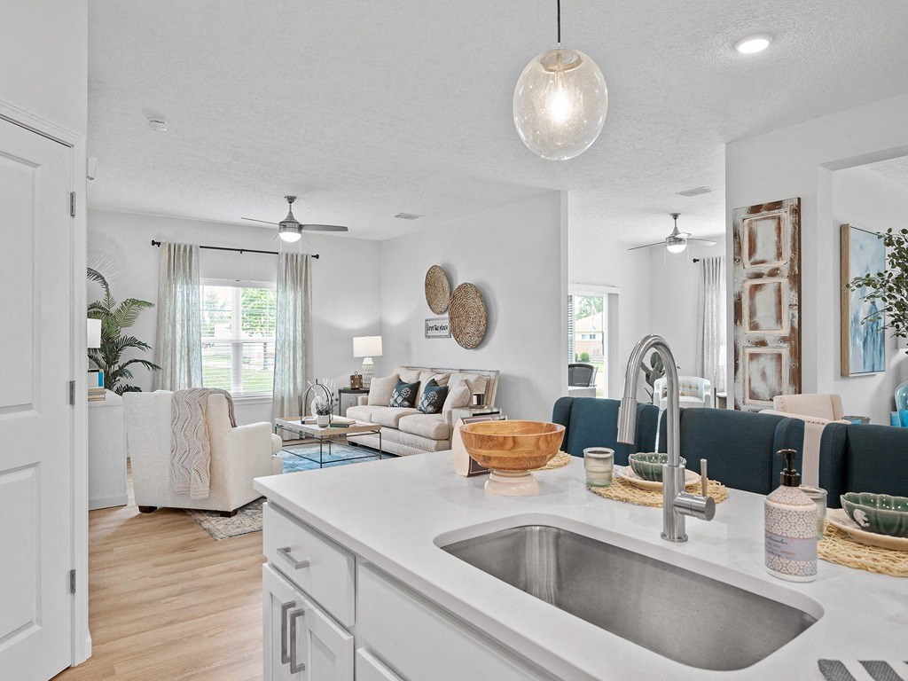 a kitchen with a sink and a view of a living room