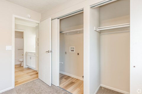 A white door is open to a room with a bed and a small table.
