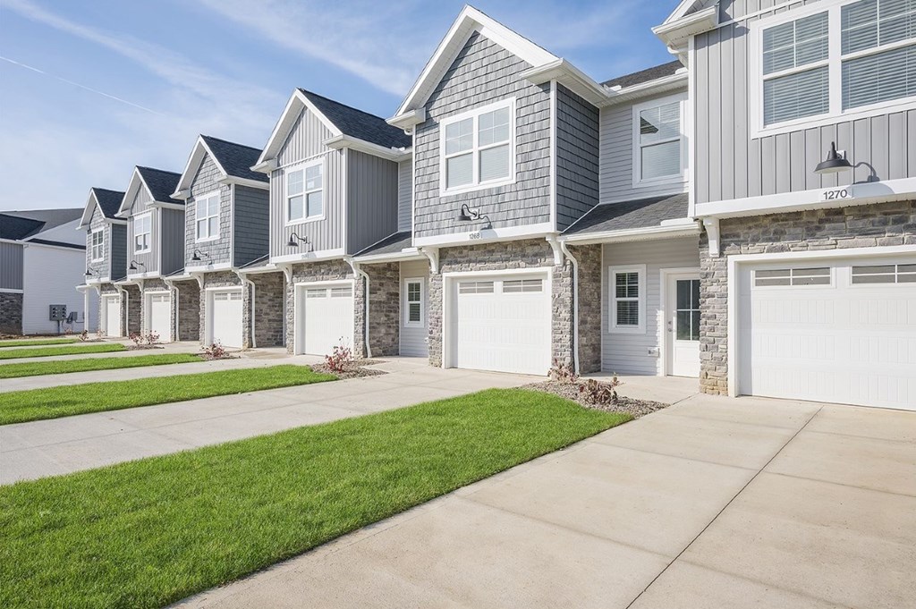 A row of houses with garages and driveways.