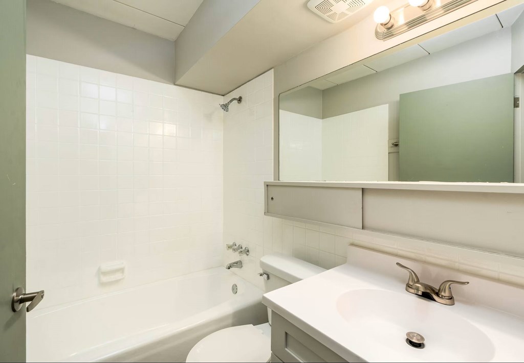 A white bathroom with a toilet, sink, and bathtub.