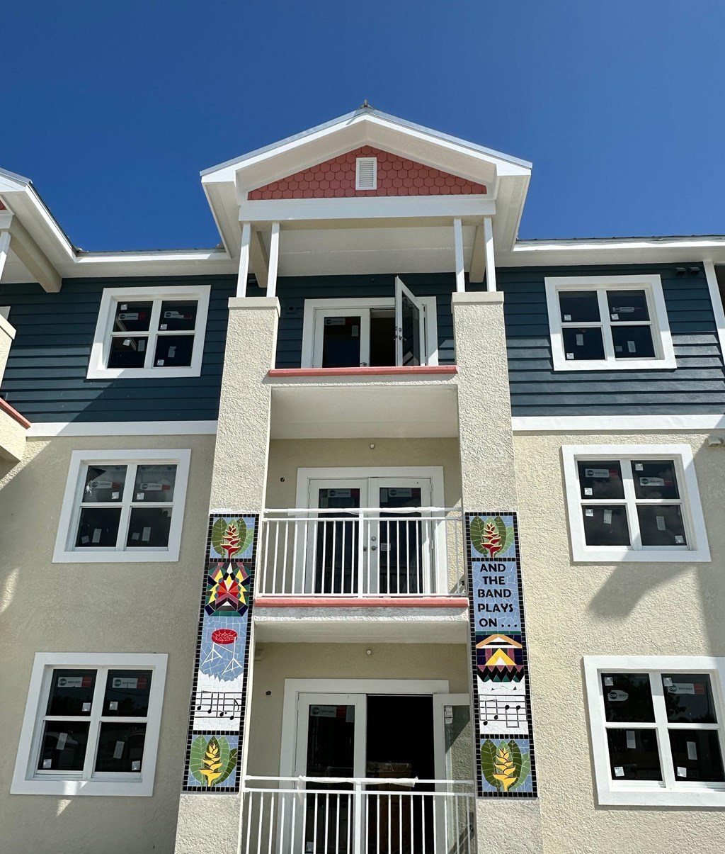 A building with a balcony and a sign that says "And the band plays on".