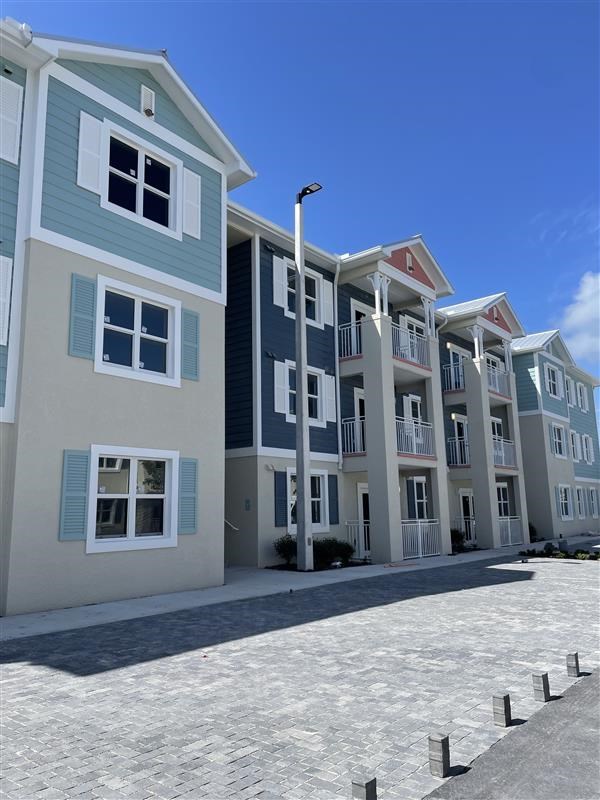 A row of multi-story buildings with balconies and shutters.