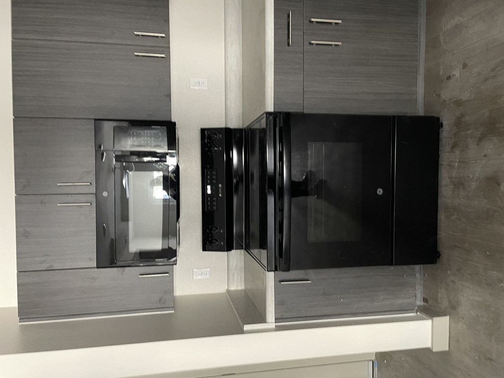 A black refrigerator is on the right and a black freezer is on the left.
