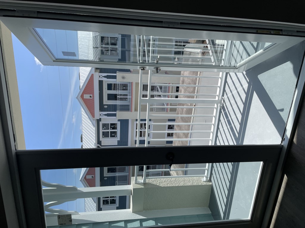 A view from inside looking out through a window at a building.