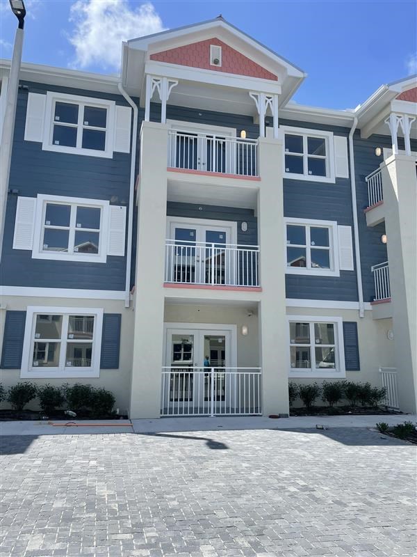 A multi-story building with a red roof and white railings.