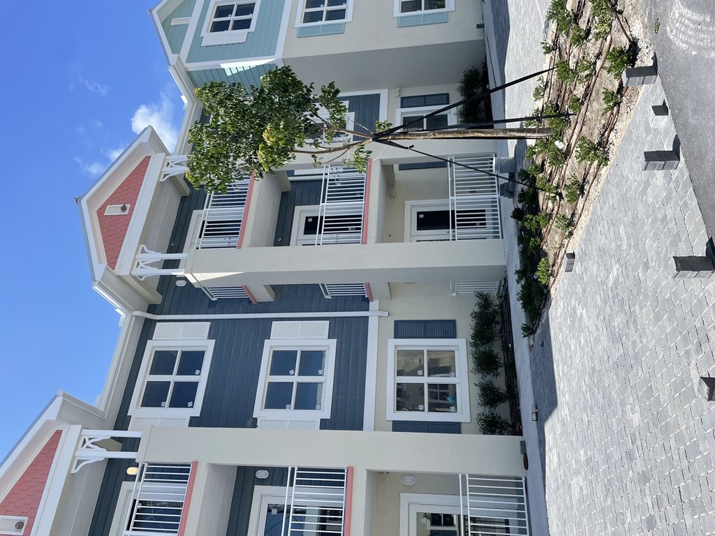 A building with a red roof and white walls with windows and balconies.