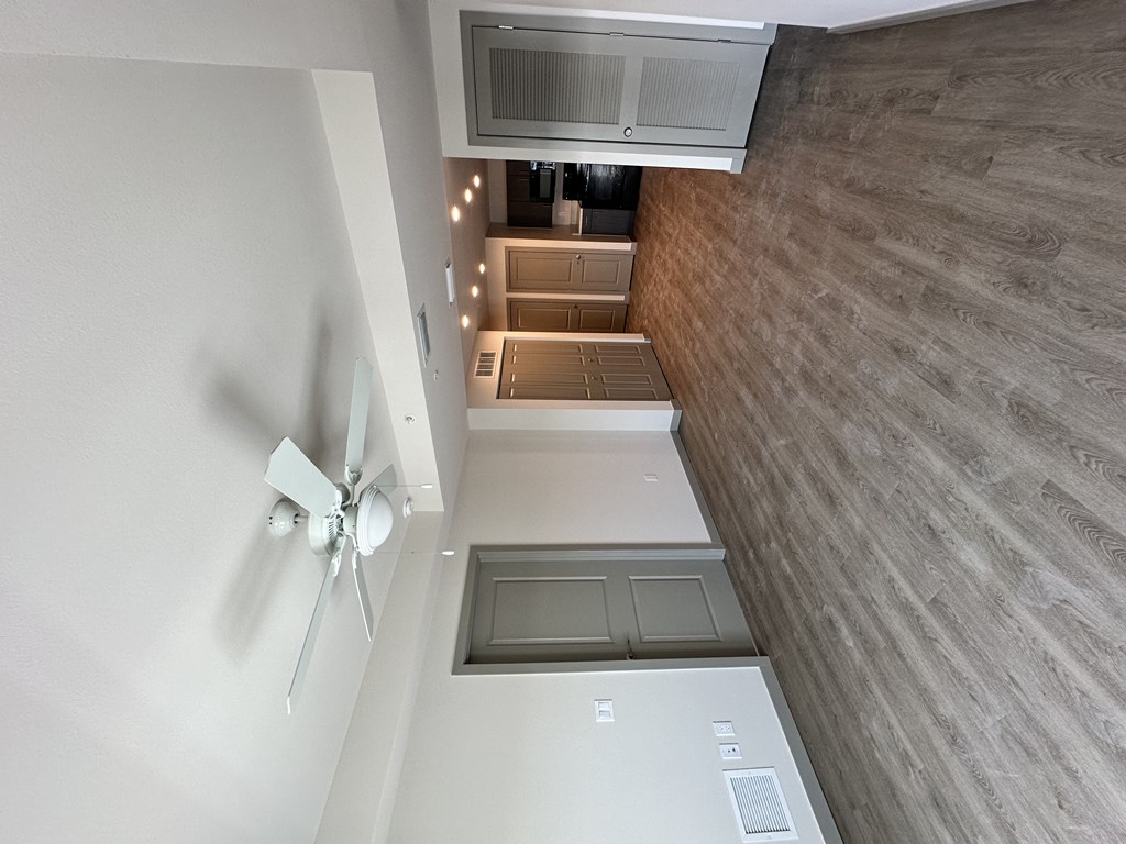 A white ceiling fan is mounted on a white wall.