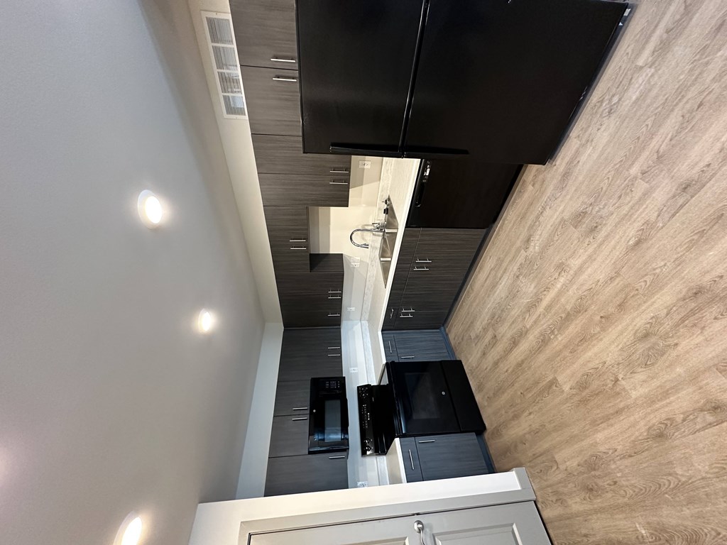 A kitchen with a black counter top and a white cabinet.