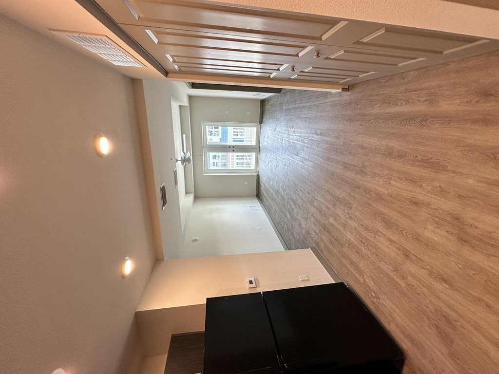 A room with a black desk and a window.