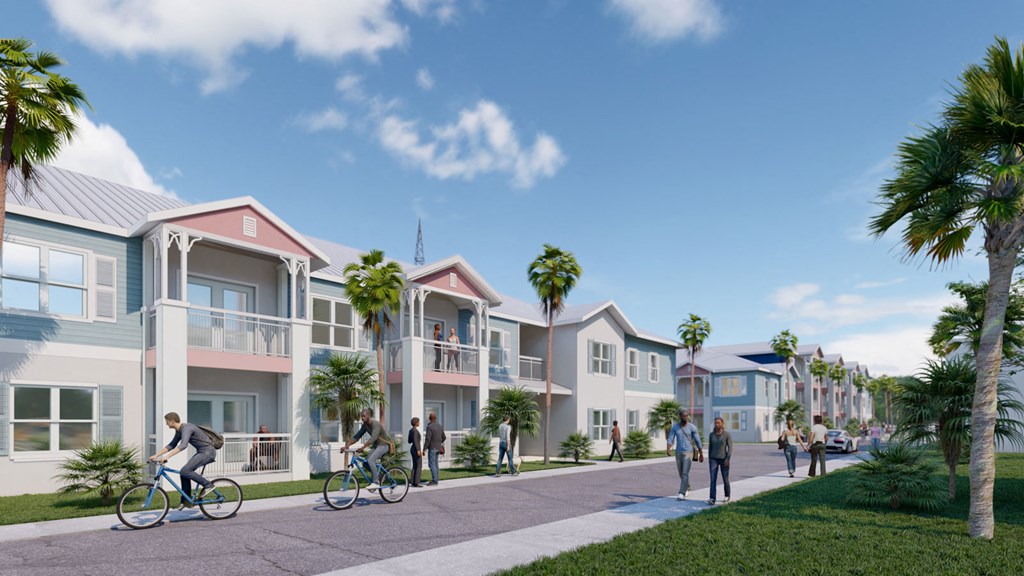 A group of people are riding bikes on a path in front of a row of townhouses.