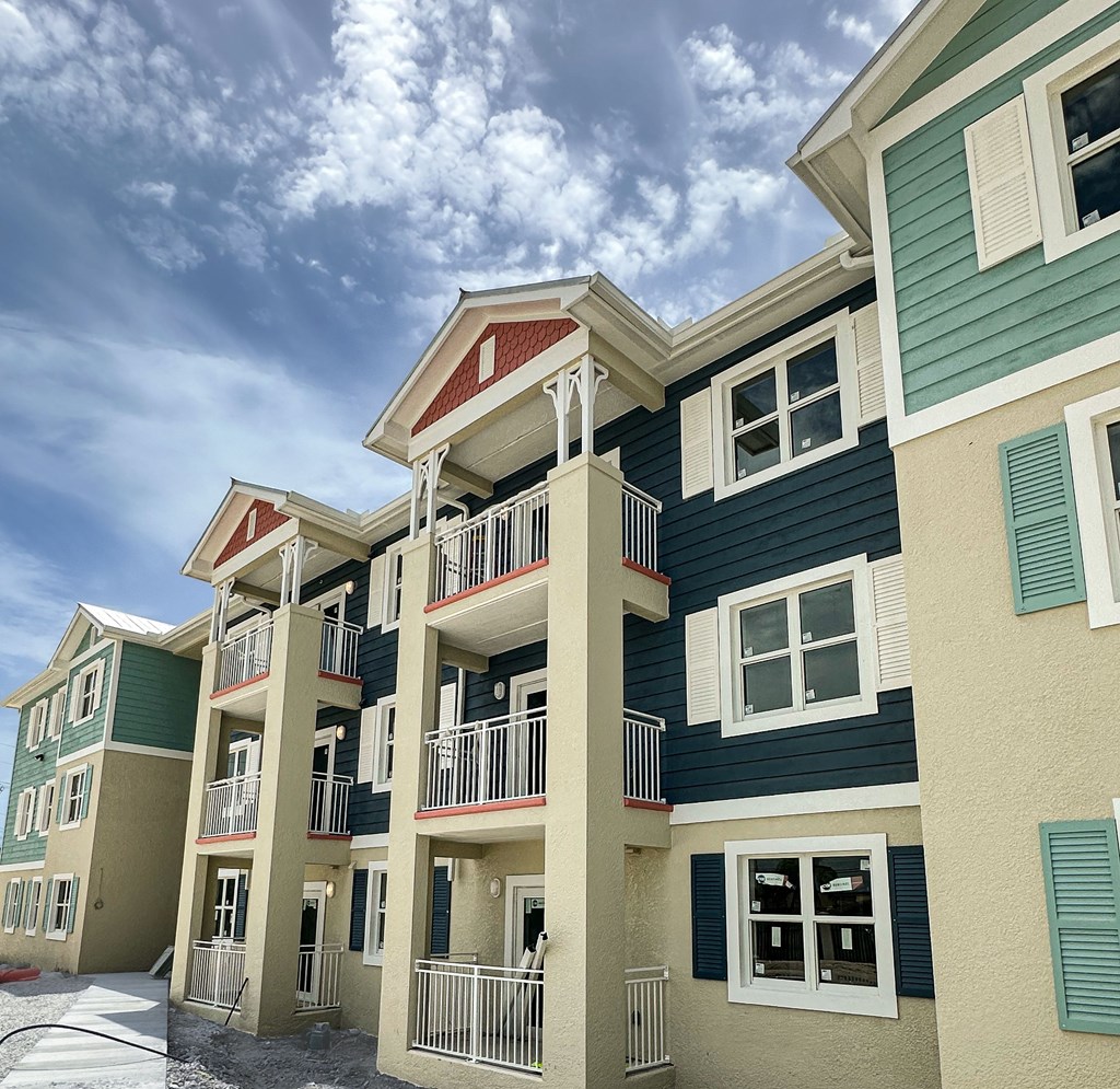 A row of multi-story buildings with balconies and windows.