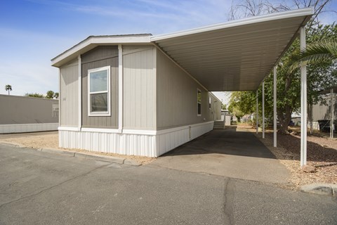 A small house with a grey roof and a white wall.