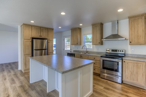 A kitchen with wooden cabinets and a stainless steel oven.