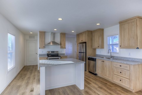 A kitchen with wooden cabinets and a white island.