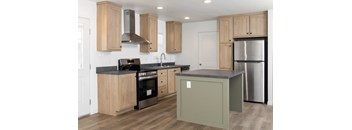 A kitchen with wooden cabinets and a black countertop.