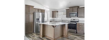 A kitchen with a refrigerator, microwave, oven, and sink.