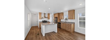 A kitchen with wooden cabinets and a white island.