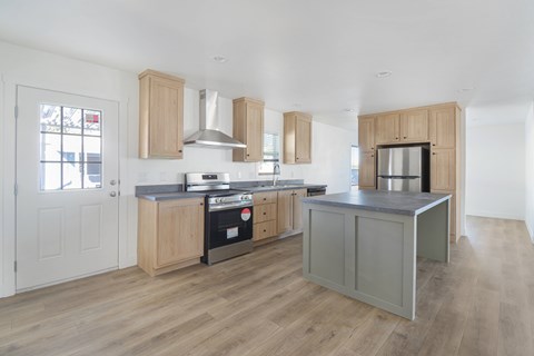 A kitchen with wooden cabinets and a grey island.