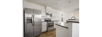 A modern kitchen with stainless steel appliances and white cabinetry.