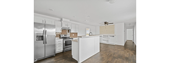 A modern kitchen with white cabinets and stainless steel appliances.