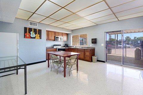 A kitchen with a table and chairs.