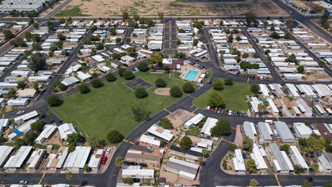 A bird's eye view of a neighborhood with houses and a green space.