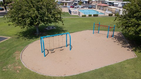 A playground with a blue swing set and a sandbox.