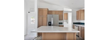 A kitchen with a refrigerator, oven, and microwave.